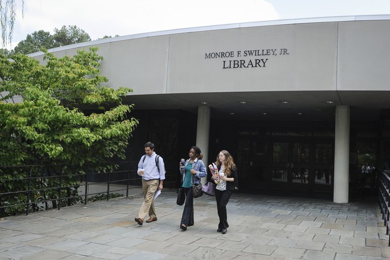 Image of the front of the Monroe F. Swilley, Jr. Library with three students exiting